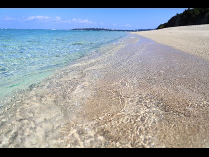 Crystal clear water washing ashore a quiet beach. 