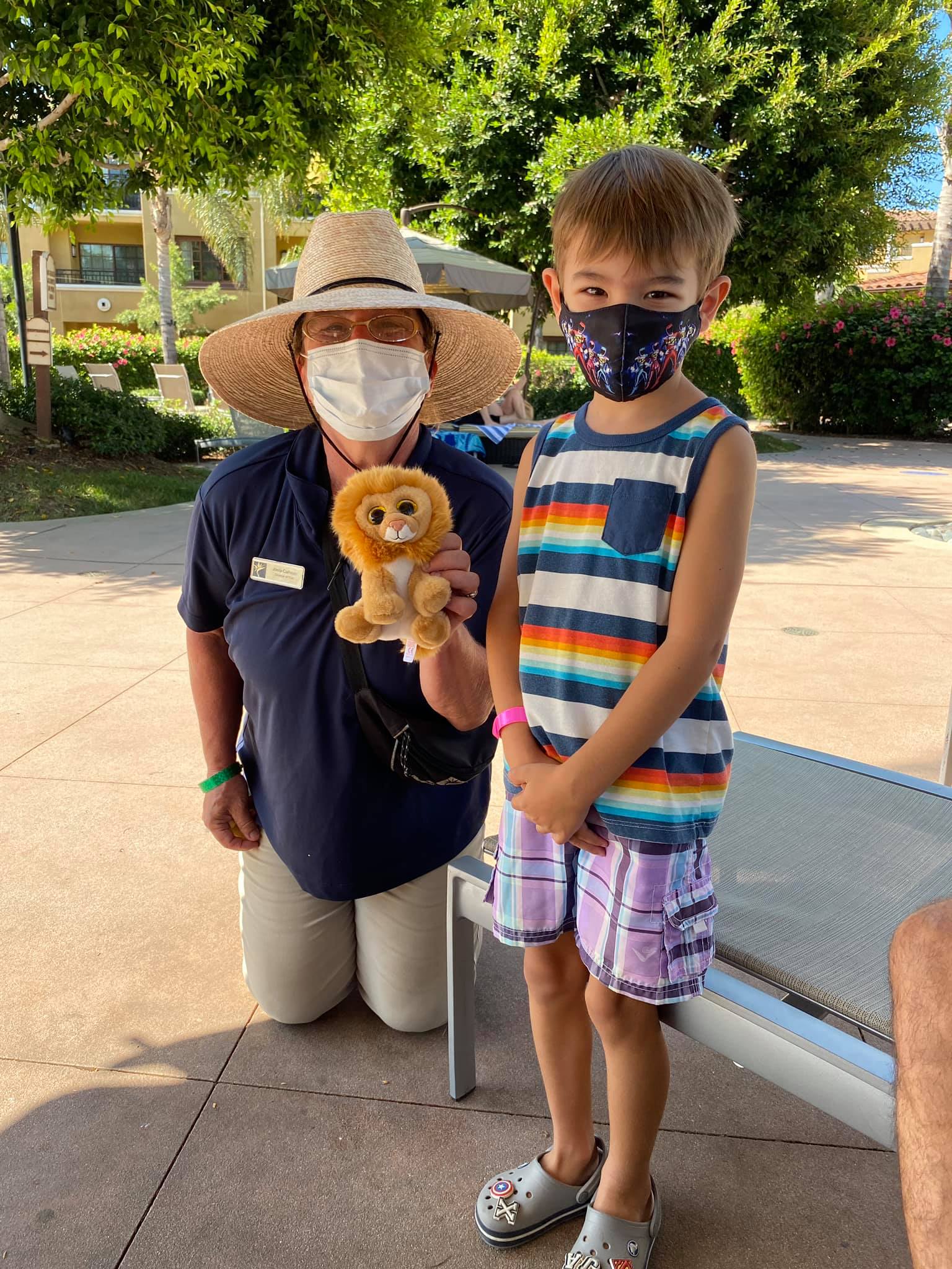 Little boy posing with Hilton Grand Vacations at MarBrisa team member.