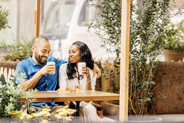 Couple drinking coffee at an outdoor cafe. 