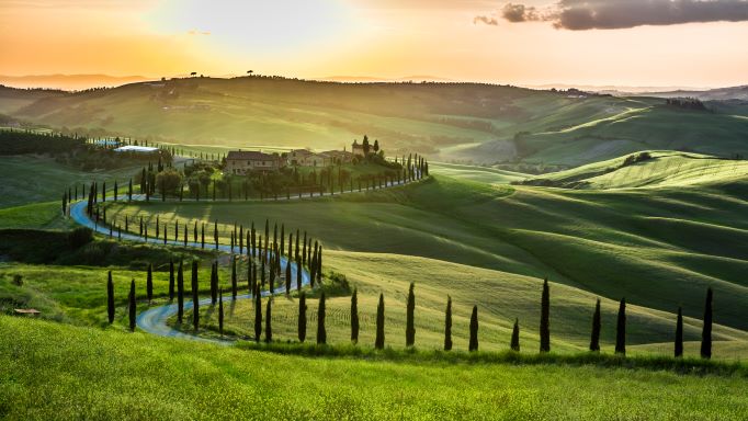 Sunrise over the verdant rolling hills of the Tuscany countryside, Italy.