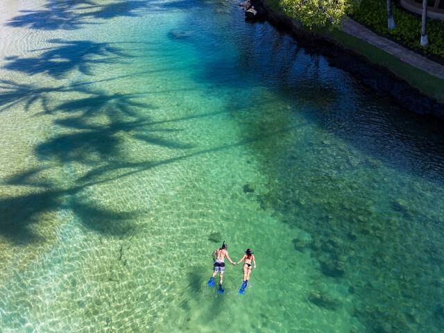 Couple snorkeling in emerald Hawaiian waters, Hilton Waikoloa Village®, Big Island, Hawaii. 