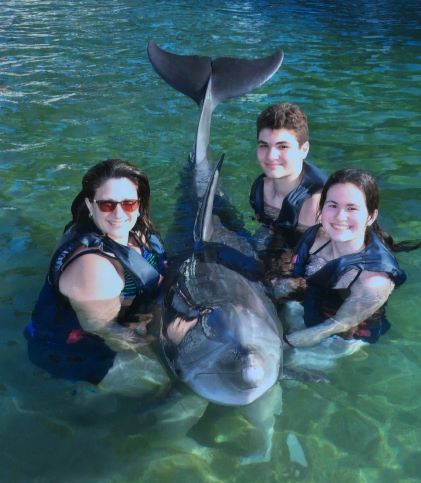Hilton Grand Vacations Owner Gina P. and her family swimming with a dolphin on the Big Island of Hawaii