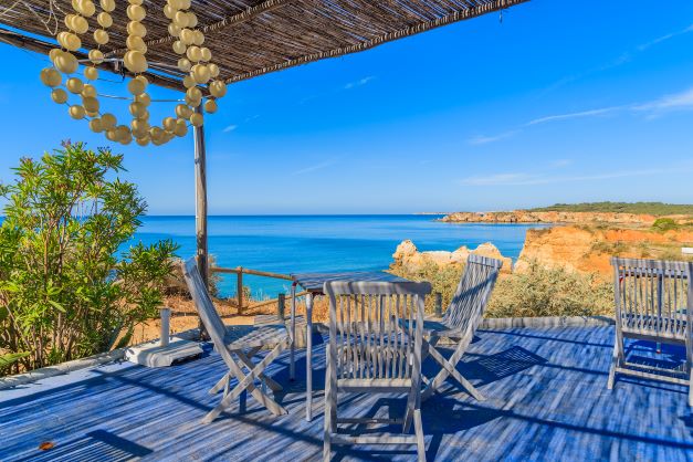 Beautiful image, table and chairs, outdoor seating, stunning coastline, Algarve, Portugal. 