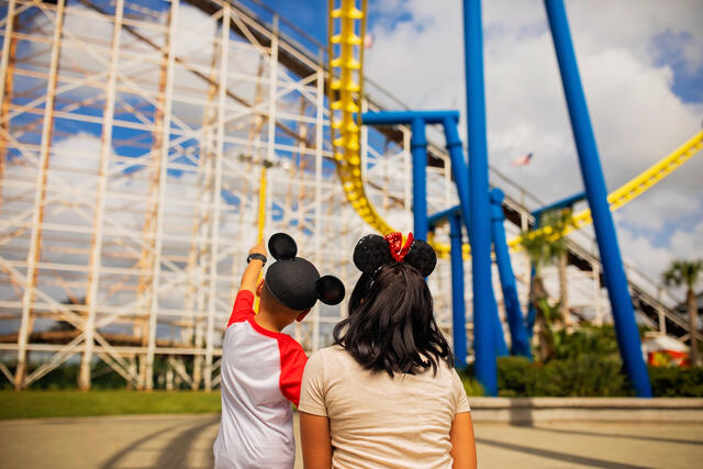 Woman and young child admiring roller coaster at Orlando theme Park, Florida. 