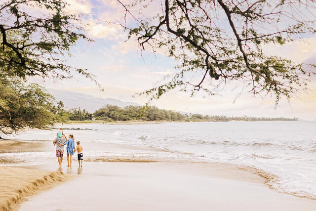 Family walking together along shoreline, Maui, Hawaii.