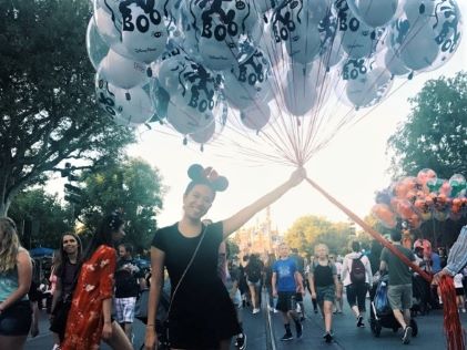 A Hilton Grand Vacations Owner poses with a bundle of balloons at Disneyland in Southern California