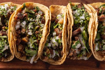 Flat lay image, traditional Mexican tacos lined up, New York City street food. 