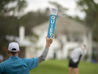 A volunteer holds a sign that says, "Quiet" during the Hilton Grand Vacations Tournament of Champions