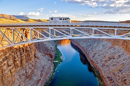 Beautiful aerial shot of a recreational vehicle driving on a bridge over the Colorado River