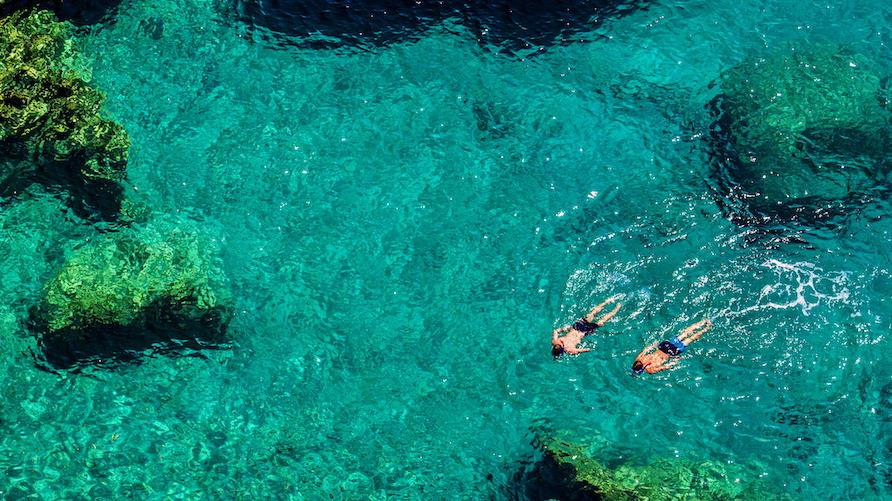 Gorgeous aerial view of a couple snorkeling in crystal clear waters