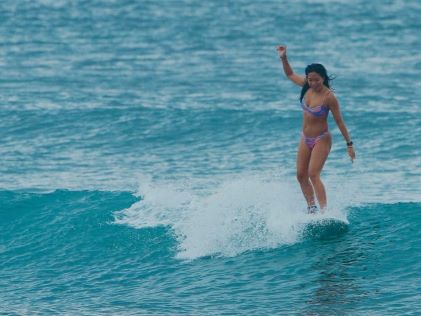 A Hilton Grand Vacations Member surfing while on vacation to Bali, Indonesia