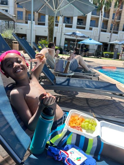 A Hilton Grand Vacations Member's son smiling by the pool at Las Palmeras, a Hilton Grand Vacations Club