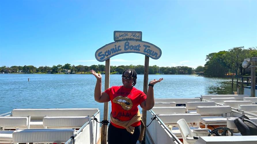 A Hilton Grand Vacations Member posing by the bank of Lake Osceola while on spring break in Florida