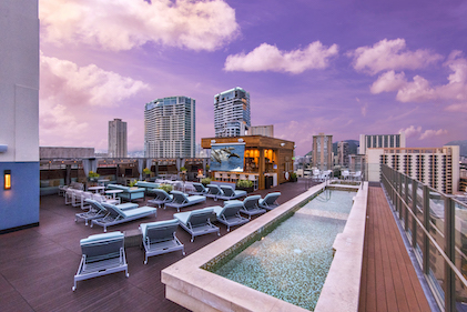 Sunset view of the rooftop plunge pool and lounge at Hokulani Waikiki, a Hilton Grand Vacations Club, Honolulu, Hawaii