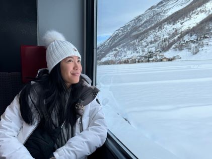 A Hilton Grand Vacations Member looking out of a train window onto a snowy destination
