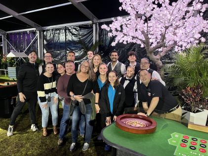 Hilton Grand Vacations Members posing for a group picture after a casino night event held as a package with the 2024 Hilton Grand Vacations Tournament of Champions