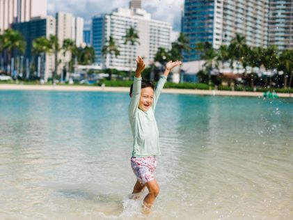 A child plays in the lagoon at Hilton Hawaiian Village in Oahu, Hawaii