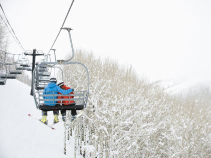 A couple rides a ski lift in Park City, Utah, in winter