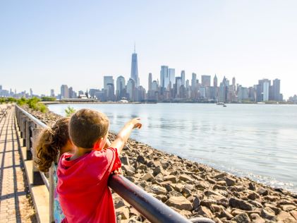 Two children point at the New York City skyline