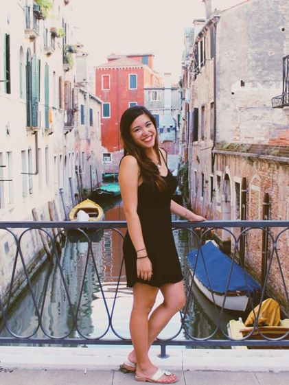 A Hilton Grand Vacations Member posing by a canal in Venice, Italy