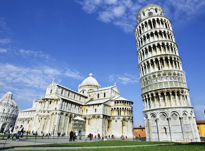 Stunning ground level image looking up at the Tower of Pisa and the cathedral complex. The white stone stands in contrast against deep blue skies.