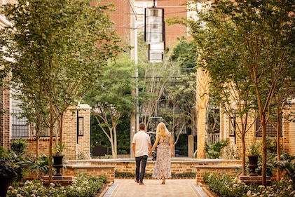 Image of a couple strolling through the courtyard at Liberty Place Charleston, a Hilton Club.