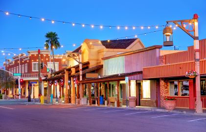 Quiet local main street shops, dusk skies, market lights overhead, Old Town, Scottsdale, Arizona. 