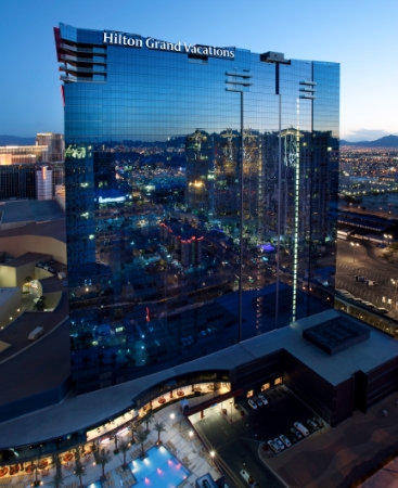 The Elara resort building with the windows reflecting the Las Vegas city illuminated at night.